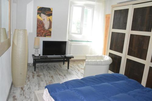 a bedroom with a bed and a tv in it at Villa Gioia in Acqui Terme