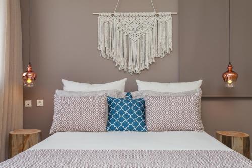a bedroom with a bed with pillows and a chandelier at Althea Maisonettes in Áptera