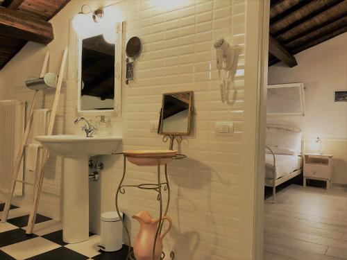 baño con lavabo, espejo y cama en Il Contado -room and breakfast-, en Castelfranco Emilia