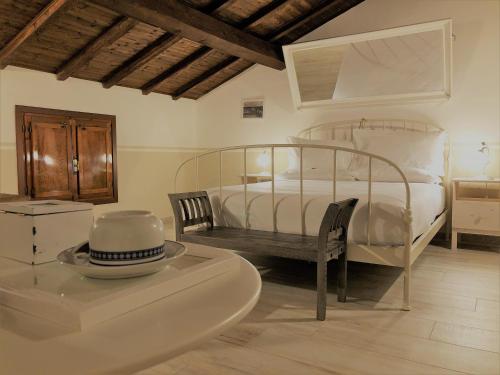 1 dormitorio con 1 cama blanca, mesa y sillas en Il Contado -room and breakfast-, en Castelfranco Emilia