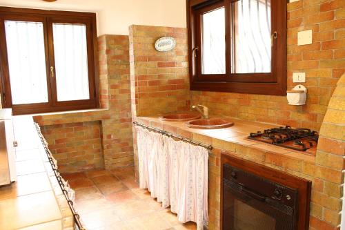 a kitchen with a stove and a counter top with a sink at Villa Porto Rais in Carini