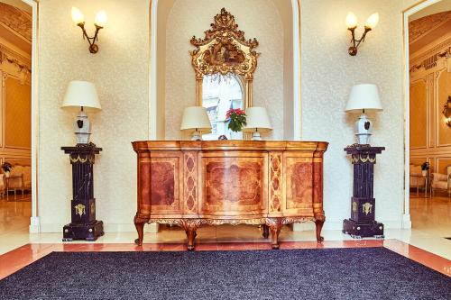 a room with a bed with two lamps and a mirror at Grand Hotel Continental Bucuresti in Bucharest