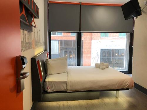 a bed in a room with a large window at easyHotel Birmingham in Birmingham