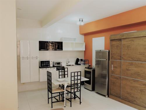 a kitchen with a table and chairs and a refrigerator at 10 Studios in Sao Paulo