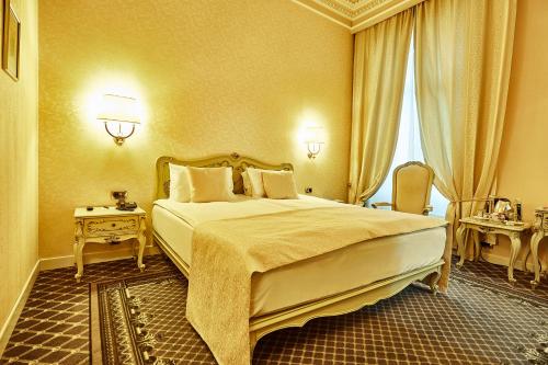 a hotel room with a large bed and a window at Grand Hotel Continental Bucuresti in Bucharest