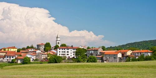 a town with a church in the middle of a field at B&B LOKEV Sezana in Lokev
