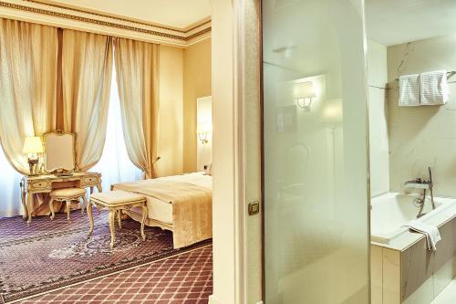 a hotel room with a bed and a bathroom at Grand Hotel Continental Bucuresti in Bucharest