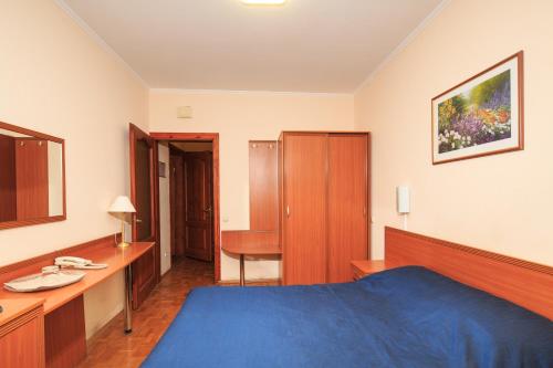 a bedroom with a blue bed and a desk at Zhayvir in Kyiv