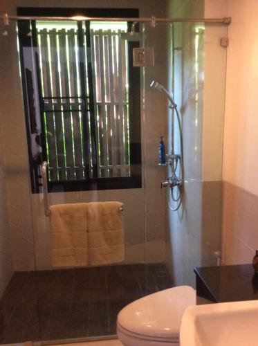a bathroom with a glass shower with a toilet at Panorama Pool Villa in Khao Tao