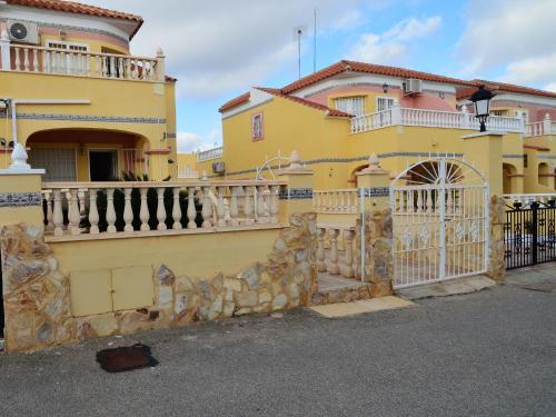a yellow house with a gate and a fence at Belvilla by OYO Casa da Costa in Villamartin