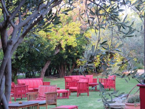 a group of red chairs and tables in a park at Beautiful holiday home near the beach in Santa-Lucia-di-Moriani