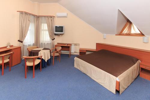 a hotel room with a bed and a table and chairs at Zhayvir in Kyiv