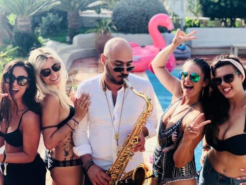 a group of women in bathing suits and a man playing a saxophone at Athina Studios and Suites Plaka in Plaka