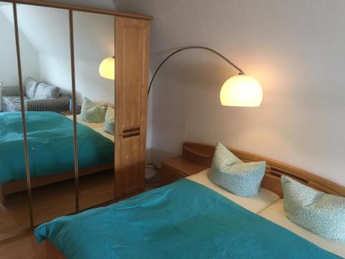 sypialnia z łóżkiem z niebieską pościelą i lustrem w obiekcie Ferienwohnung Deichgraf w mieście Westerland