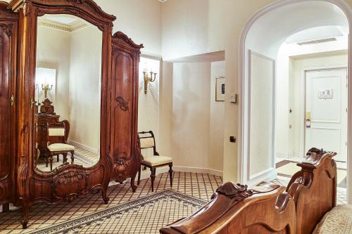 a room with a large mirror and a chair at Grand Hotel Continental Bucuresti in Bucharest