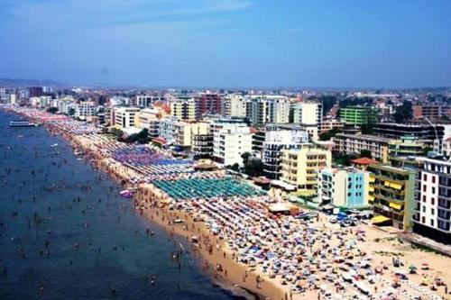 una spiaggia con molti ombrelloni e folle di persone di Fati Guest House a Durrës