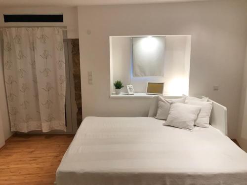 a white bed in a room with a window at Büdinger Hof in Weinheim