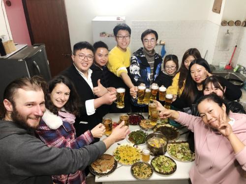 a group of people sitting around a table with food at Hotel Darwin in Kathmandu