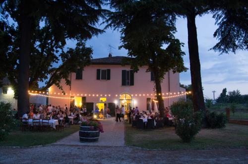 a group of people sitting at tables in front of a building at Locanda Corte Roveri in Bologna