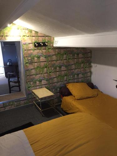 sypialnia z 2 łóżkami i ceglaną ścianą w obiekcie le lutin sur le toit w mieście Mazan