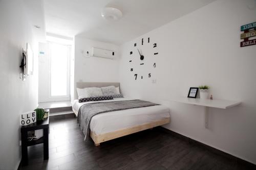 a bedroom with a bed and a clock on the wall at Stunning Studio By The Beach With Free Parking in Tel Aviv