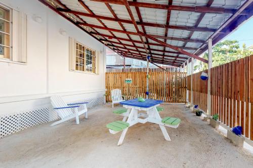 um pátio com uma mesa, cadeiras e uma cerca em Casa DV Suites em Caye Caulker