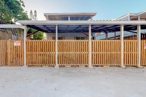 a wooden fence with a pavilion in front of a building at Casa DV Suites in Caye Caulker