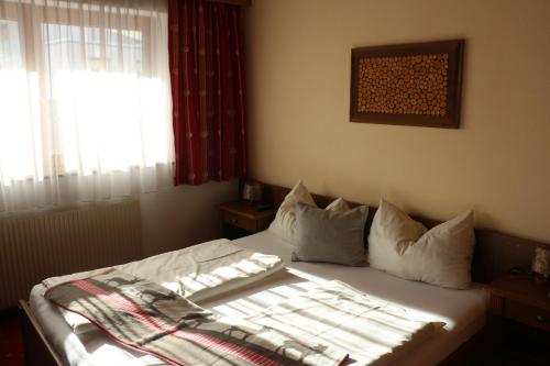 a bed in a room with a window and a bed sidx sidx sidx at Pension Singer in Innsbruck