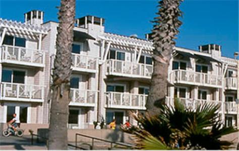 a large white building with palm trees in front of it at Beach House Hotel at Hermosa Beach in Hermosa Beach