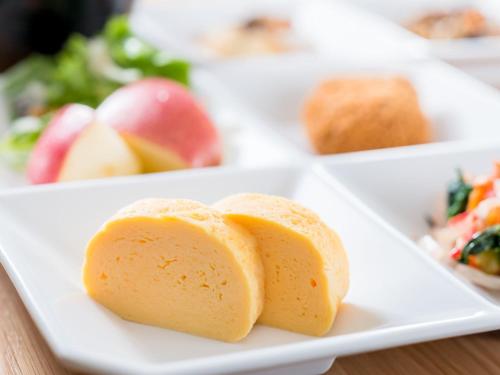 a white plate with two pieces of bread on it at Super Hotel Takamatsu Kin en kan in Takamatsu