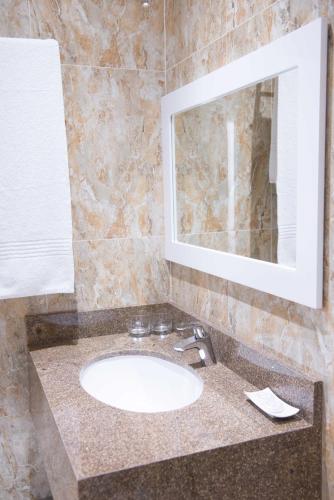 a bathroom with a sink and a mirror at Britannia Hotel in Durban