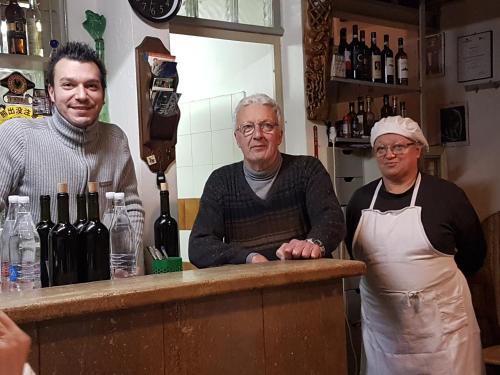 een groep van drie mannen die aan een bar staan bij Albergo Locanda Garibaldi in Siena