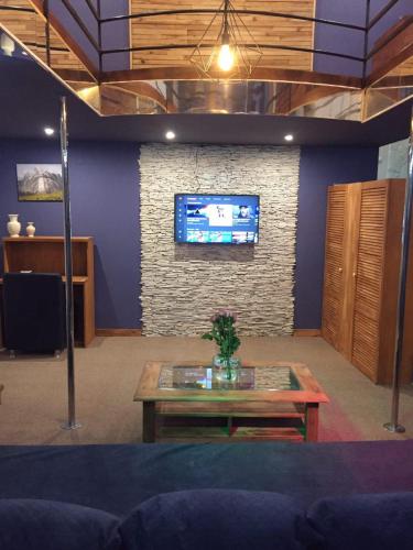 a living room with a table and a tv on a wall at WINE & ROSE BOUTIQUE HOTEL in Kharkiv