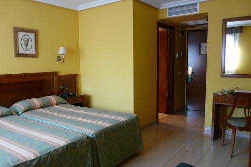 1 dormitorio con cama, mesa y escritorio en Idh Angel, en Oviedo