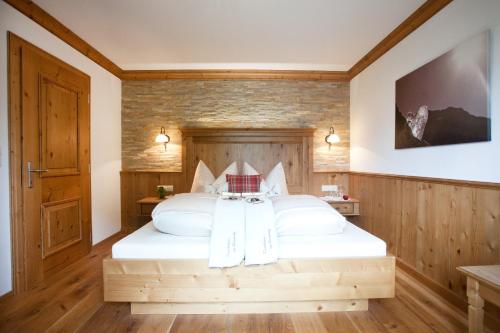 Schlafzimmer mit einem großen weißen Bett und Holzwänden in der Unterkunft Brixnerhof im Zillertal in Schlitters