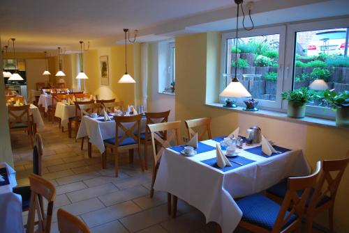 un restaurante con mesas y sillas blancas y una ventana en Hotel Lohmann, en Münster