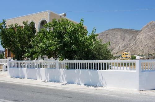 a white fence on the side of a road at Margarita in Perissa