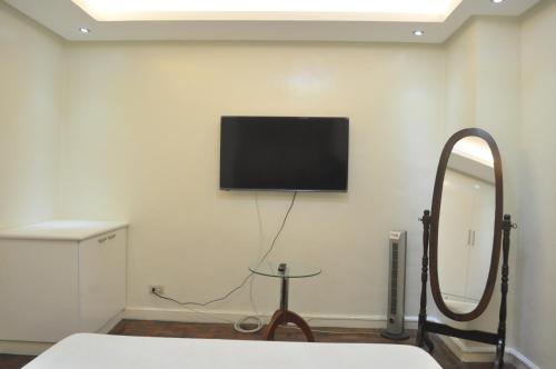 a room with a flat screen tv on a wall at Golden Queen Suites in Baguio
