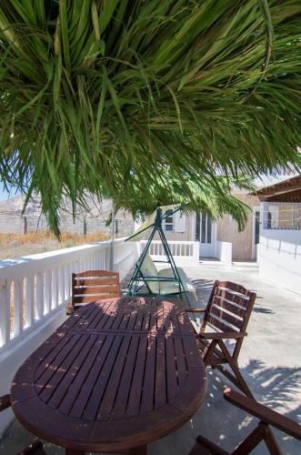 a wooden table and chairs under a tree on a porch at Margarita in Perissa