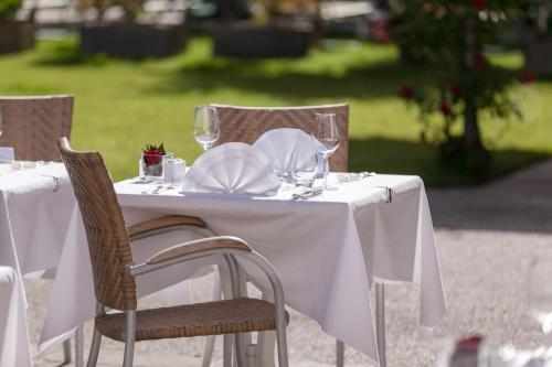 a white table with chairs and wine glasses on it at Dominik Alpine City Wellness Hotel - Adults only in Bressanone