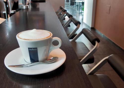 a cup of coffee sitting on a table at Old Mill Hotel in Klaipėda