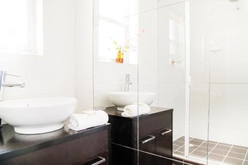 a white bathroom with a sink and a shower at Angaston Mews Apartments in Angaston