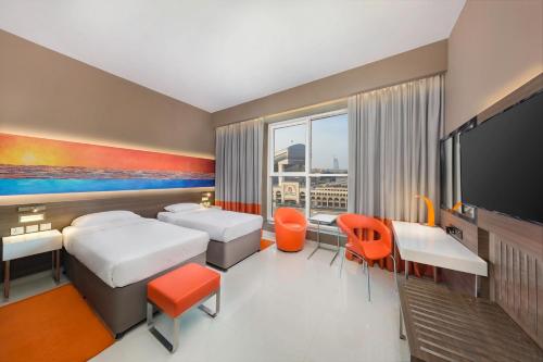 a hotel room with two beds and a flat screen tv at Citymax Hotel Al Barsha in Dubai