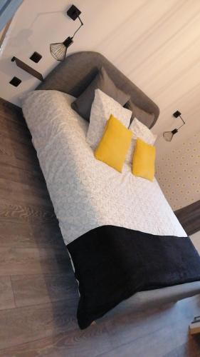 a bedroom with a bed with yellow pillows at les Pénates appartement terrasse in Saint-Max