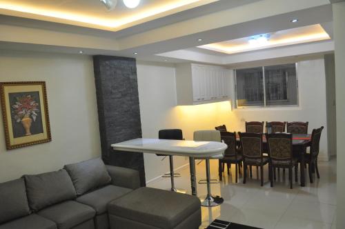 a living room with a couch and a table and chairs at Fe and Jun Condo Unit Rental in Baguio