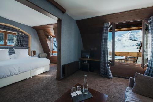 Schlafzimmer mit einem Bett und Blick auf einen schneebedeckten Berg in der Unterkunft Hôtel des Dromonts by SOWELL COLLECTION in Avoriaz