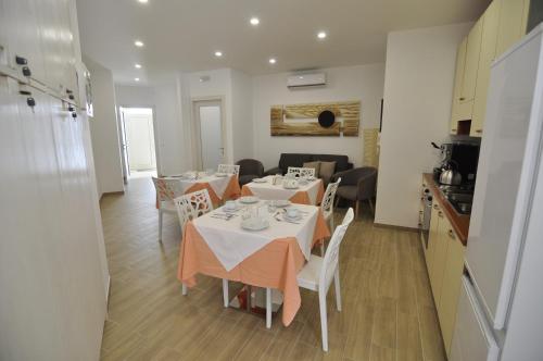 a kitchen and a dining room with tables and chairs at IL GIARDINO NASCOSTO in Portopalo