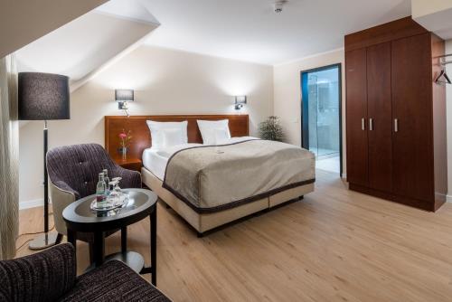 a bedroom with a bed and a table and chairs at Best Western Plus Hotel Excelsior in Erfurt