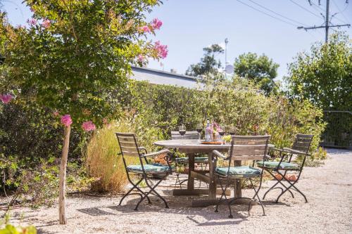 a table and chairs sitting in a garden at Mataro Cottage in Tanunda