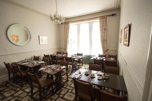 a dining room with tables and chairs and a mirror at Glenleigh Bed and Breakfast in Marazion